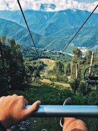 Cropped hand of person sitting on cable car