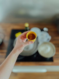 Cropped hand of woman holding coffee on table