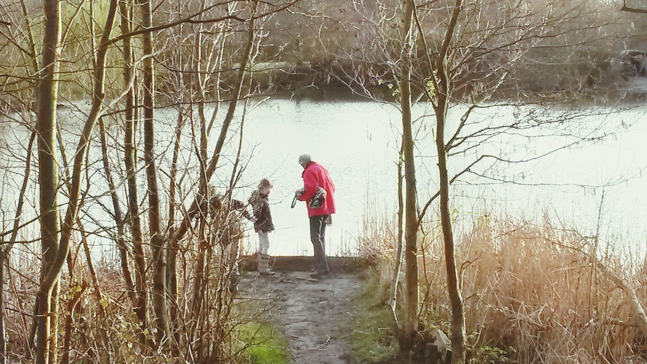 full length, lifestyles, tree, leisure activity, rear view, bare tree, water, standing, walking, casual clothing, childhood, nature, men, girls, day, red, person, elementary age