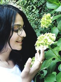 Smiling woman looking at white flowers