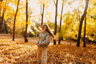 Full length of woman standing in forest during autumn