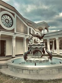 Statue of fountain in city against sky