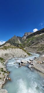 Scenic view of mountains against blue sky