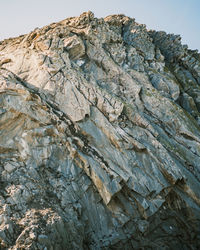 Low angle view of rocky mountains against clear sky