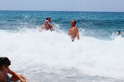 Family enjoying at beach on sunny day