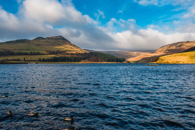 Scenic view of lake and mountains against sky