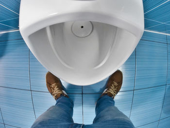 Low section of man standing in bathroom