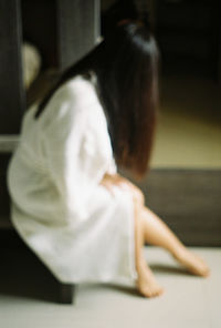 Side view of woman sitting on table