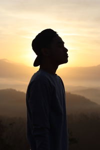 Silhouette man standing against sky during sunset