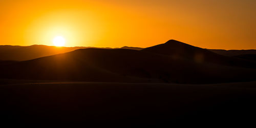 Scenic view of silhouette mountains against sky during sunset