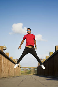 Low angle view of man jumping against sky