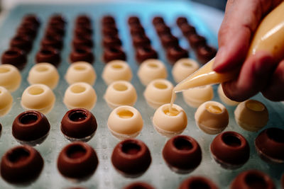 Hand filling pralines with chocolate