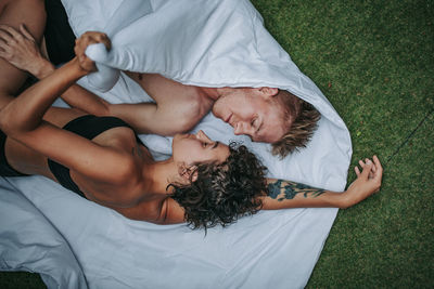 High angle view of friends relaxing on bed