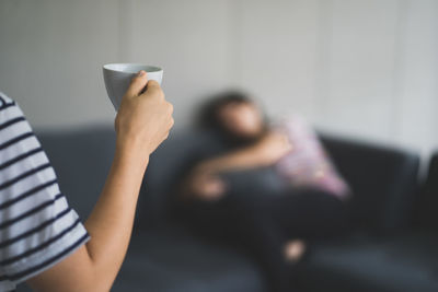 Midsection of woman holding coffee cup