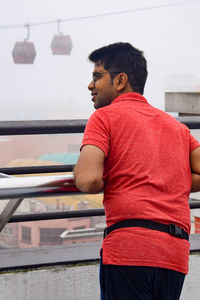 Rear view of man standing by railing