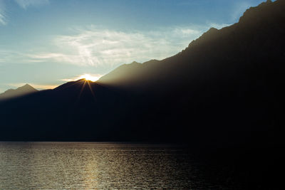 Scenic view of last sun rays against mountains silhouette on garda lake, italy