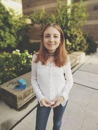 Portrait of a smiling young woman standing outdoors