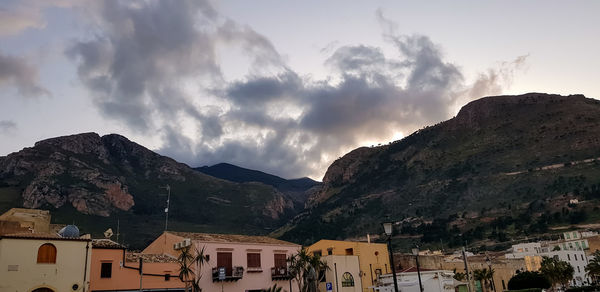 Panoramic shot of townscape by mountains against sky