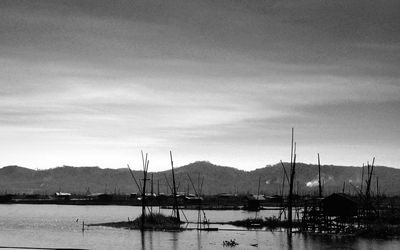 Sailboats moored in lake against sky