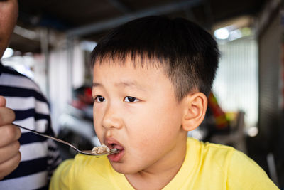 Close-up portrait of boy holding camera