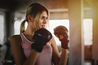 Young woman boxing at gym