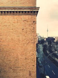 Old building by road with television tower in background