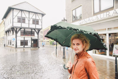 Portrait of woman standing by railing