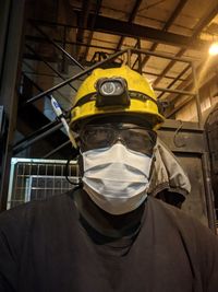 Portrait of man wearing mask in factory