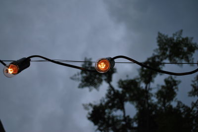 Low angle view of illuminated street light against sky