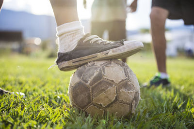 Low section of person relaxing on field