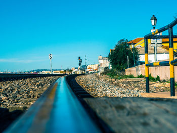 Railroad tracks against clear blue sky