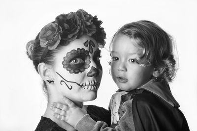 Portrait of boy with flowers against white background