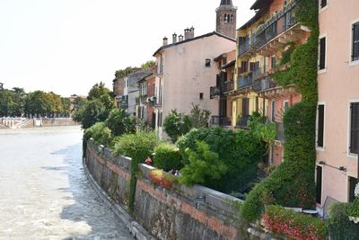 Street by buildings in town against sky