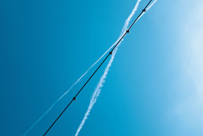 Low angle view of vapor trail against clear blue sky