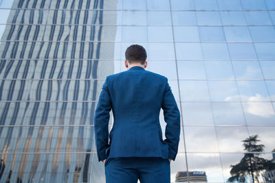 Rear view of man with umbrella standing in office building