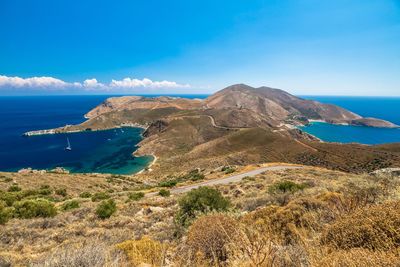 Scenic view of sea and mountains against blue sky