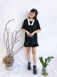 Fashion shot of a asian woman in black dress isolated over white background