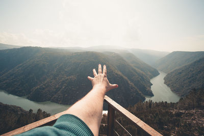 Midsection of person on mountain against sky