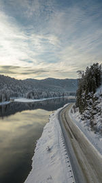 Snow covered landscape against sky during sunset