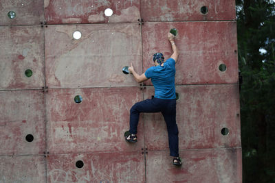 Full length of young man jumping on wall