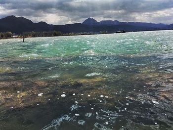 Scenic view of sea and mountains against sky