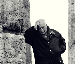 Portrait of man standing against stone wall