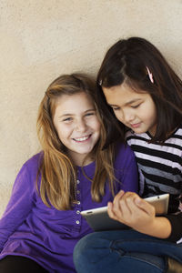 Portrait of two girls with digital tablet