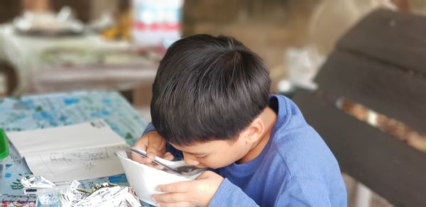 Close-up of boy sitting on table