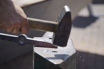 Close-up of person working on metal