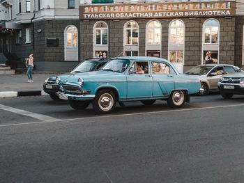 Vehicles on road against buildings in city