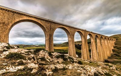 Low angle view of arch bridge against sky