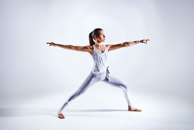 Full length of woman jumping against white background