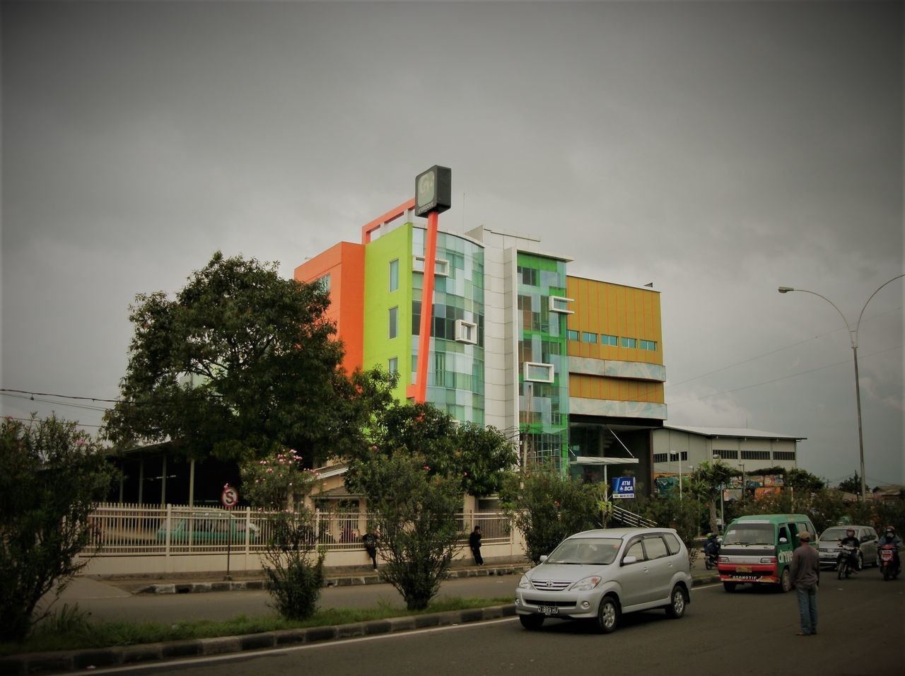 VEHICLES ON ROAD BY BUILDINGS AGAINST SKY