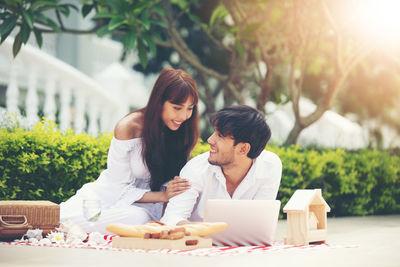 Smiling young couple looking at each other while spending leisure time outdoors